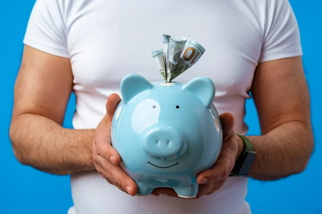Man holding a piggy bank, representing the hidden cost of templated websites.