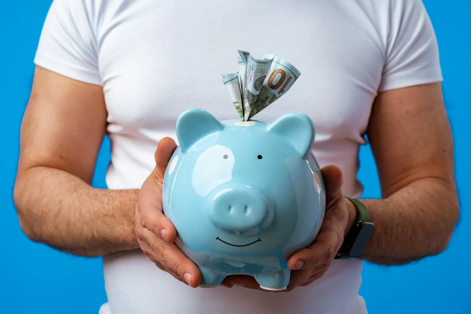 Man holding a piggy bank, representing the hidden cost of templated websites.