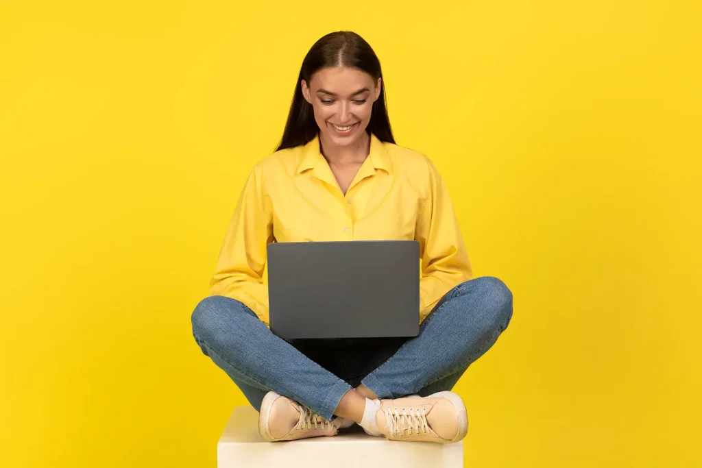 Woman browsing a website on a laptop, looking at an effective homepage design.